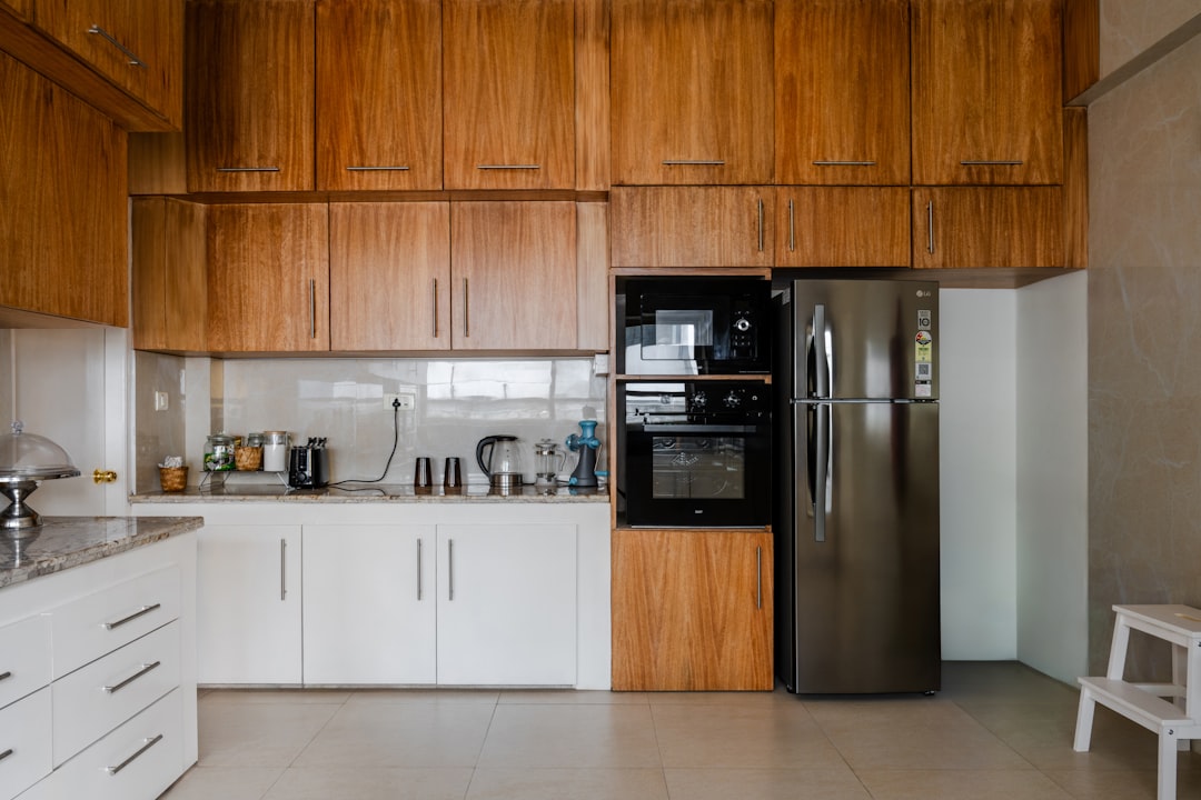 Appliance repair technician diagnosing a residential refrigerator in a Pickwick Lake area kitchen